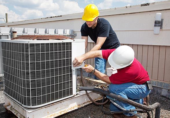 A person repairing an AC unit outside An AC repair in progress in Columbia, SC