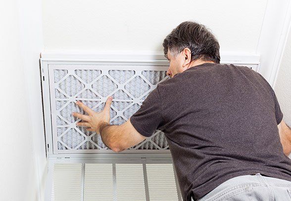 A person replacing an air filter A person replacing an air filter
