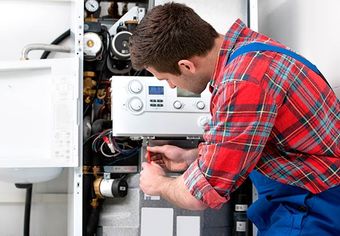 Image of person working on a heater Image of person working on a heater