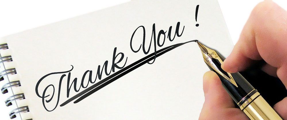 Person writing thank you with a fountain pen on a notepad