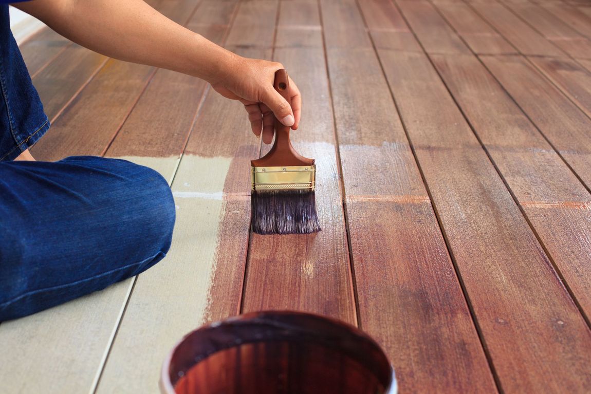 tecnico durante la verniciatura di un parquet