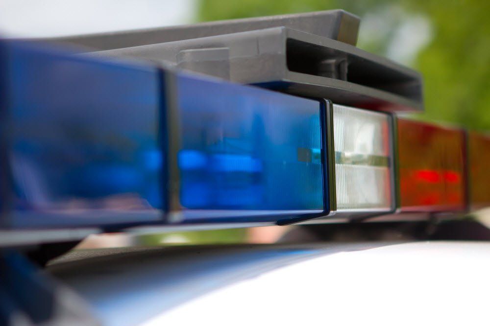A close-up of a blue, white, and red light bar mounted on the roof of a police vehicle.