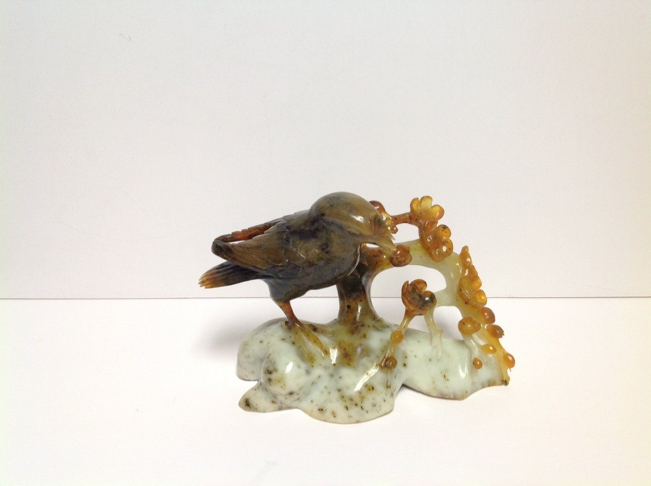 A small statue of a bird sitting on a rock