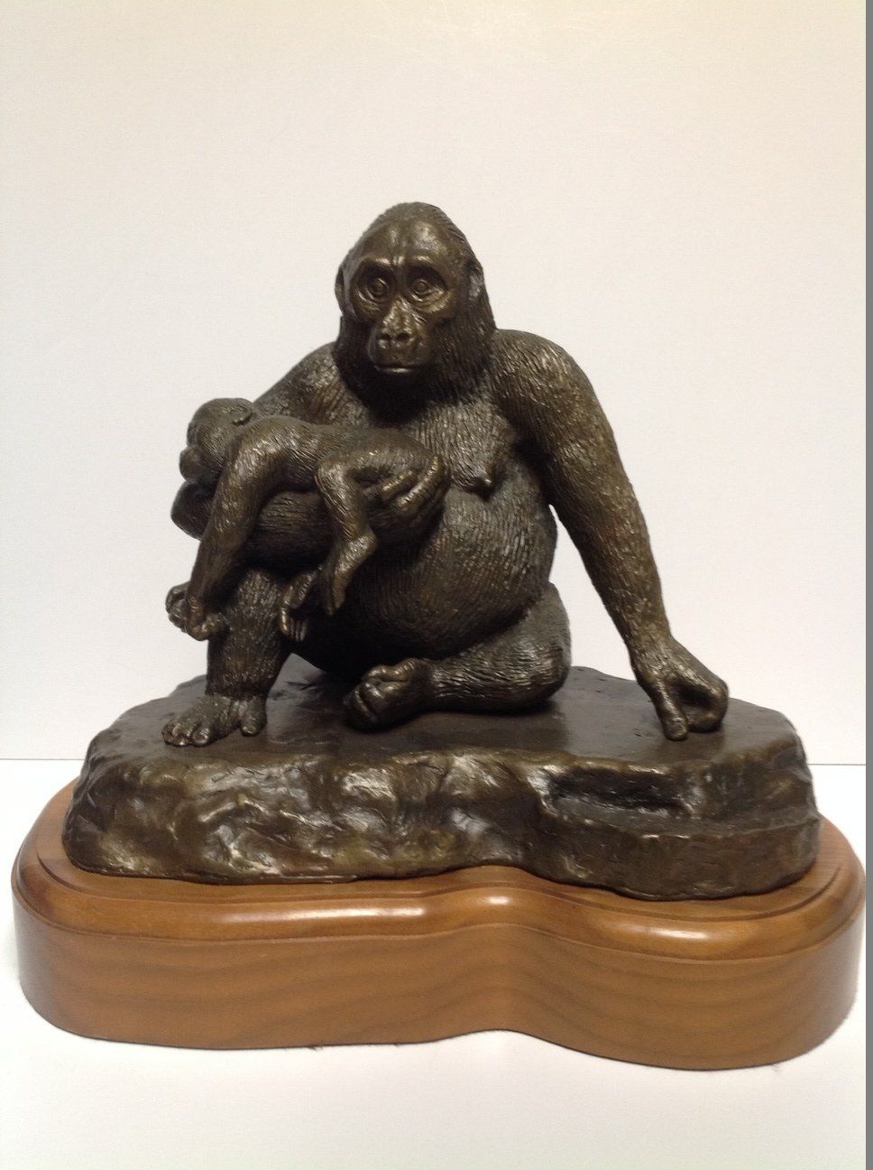 A statue of a gorilla holding a baby gorilla