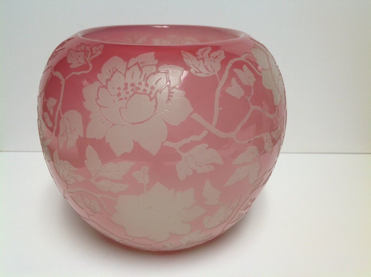 A pink vase with white flowers on it