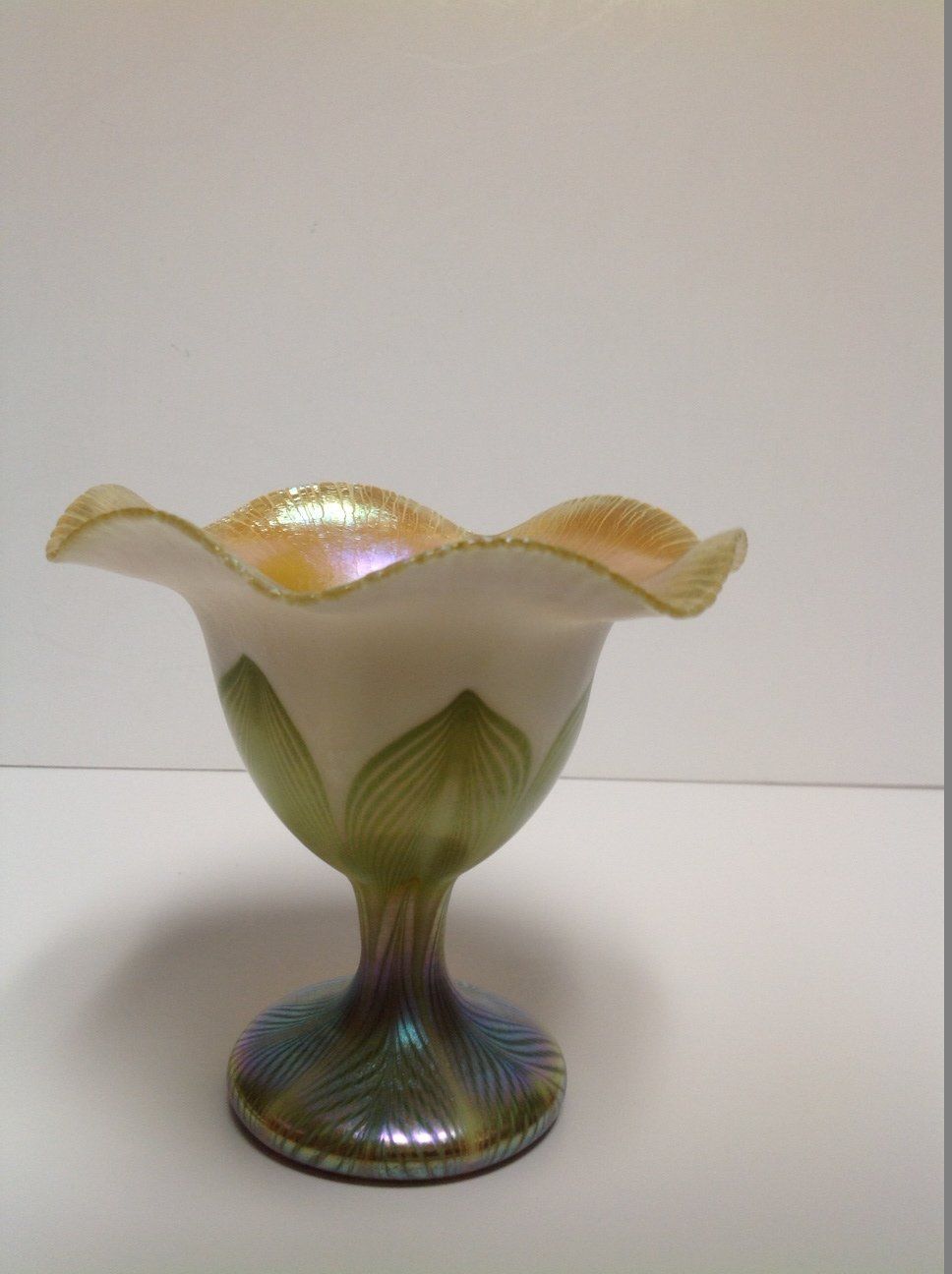 A green and white glass bowl with leaves on it