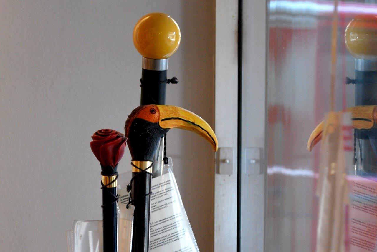Decorazione con tucani e palla riflessa su una porta di vetro, con accanto una statuetta di un uccellino rosso.