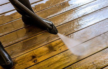 High pressure washing a worn patio.