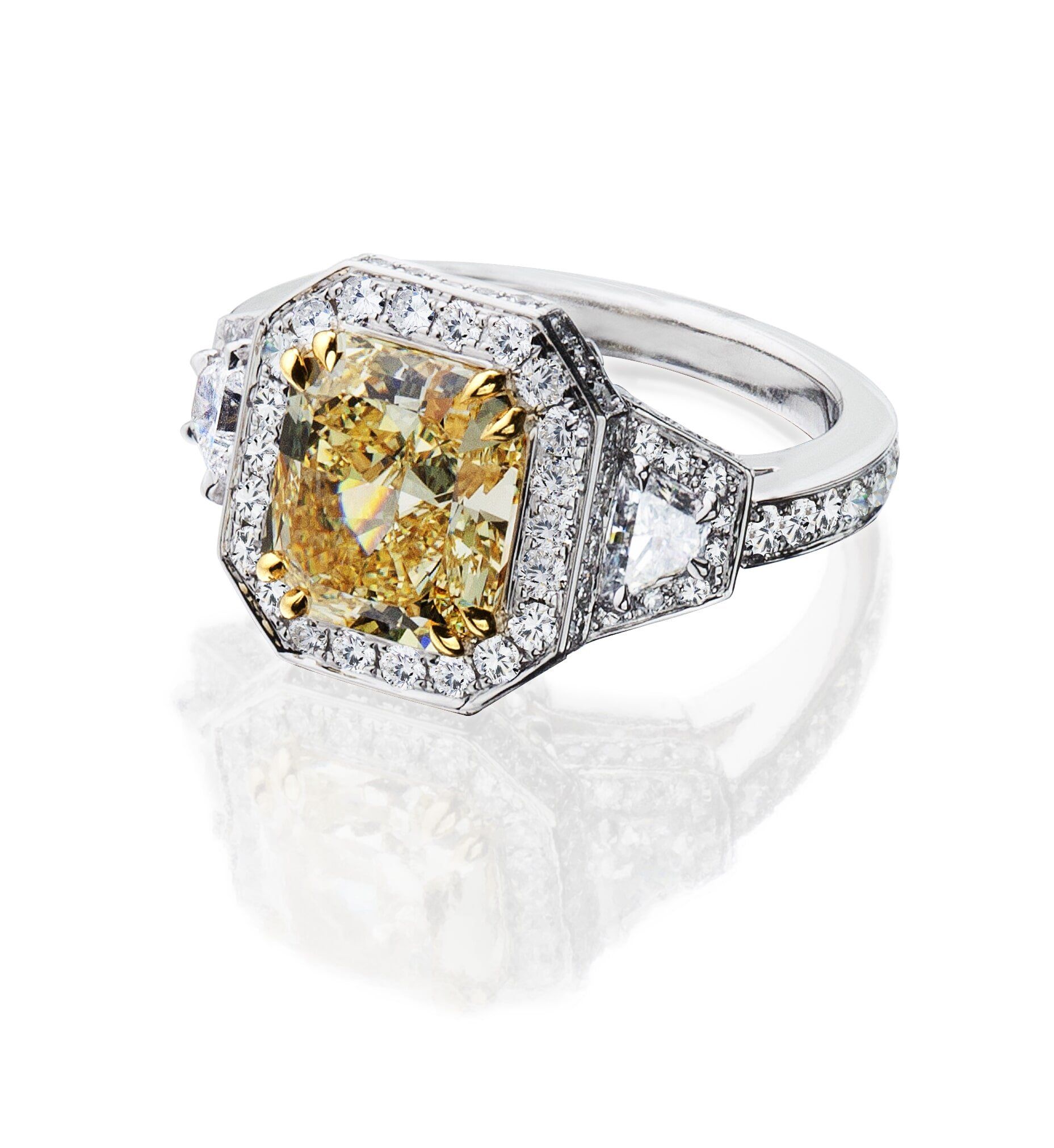 Yellow diamond ring with white diamond halo and side stones.
