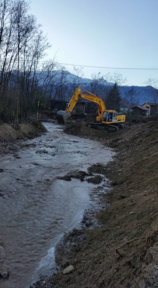 ingrandimento di una ruspa con sullo sfondo un palazzo in costruzione