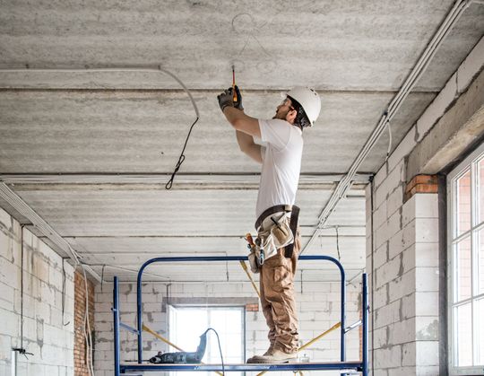 Electrician Installer With A Tool In His Hands — Elma, WA — Schumacher Electric, Inc. Electrician Installer With A Tool In His Hands — Elma, WA — Schumacher Electric, Inc.