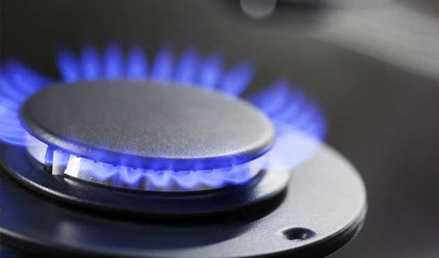 Blue flame burning from a gas stove burner.