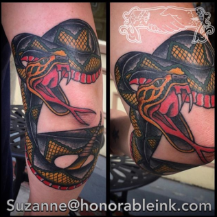 Colorful snake tattoo wrapped around a calf, with black scales, red tongue, and yellow accents.