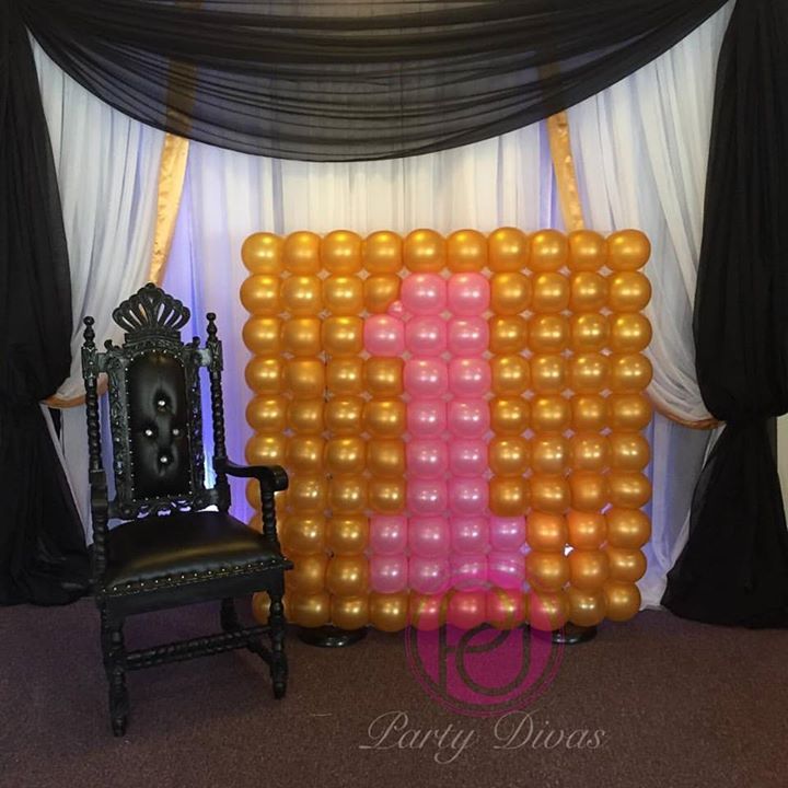 A small balloon wall with the different colors creating a 1 in the center.