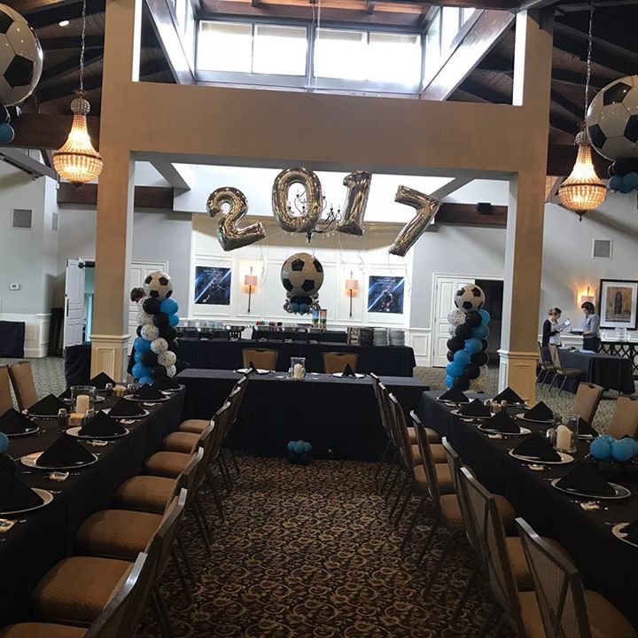 A soccer themed event with balloon columns, centerpieces and a 