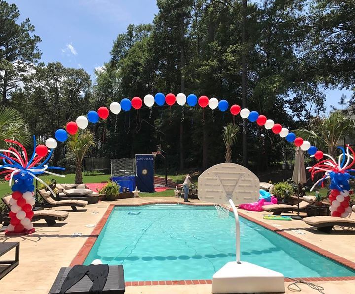 A 4th of July balloon archway over a pool 