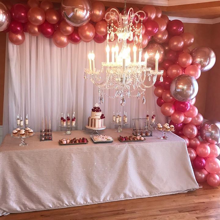 A chandelier in the foreground and a dessert table in the background