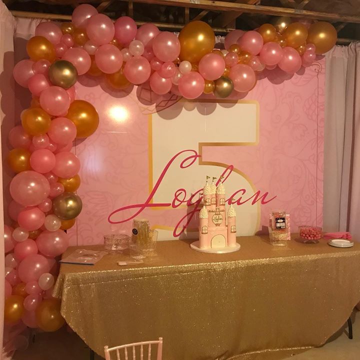 A classy dessert table for a five year old framed with an organic balloon garland.