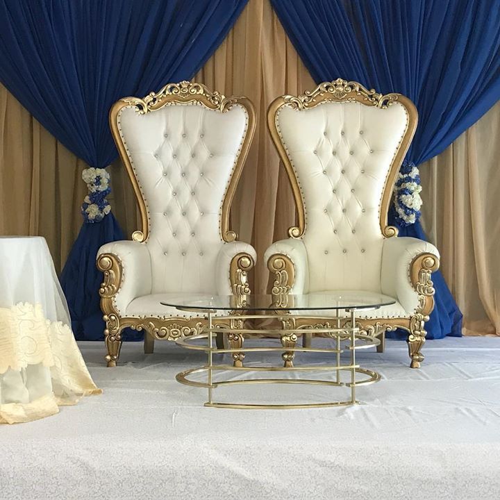 Pair of white and gold throne chairs with royal blue draped backdrop for wedding or sweetheart table