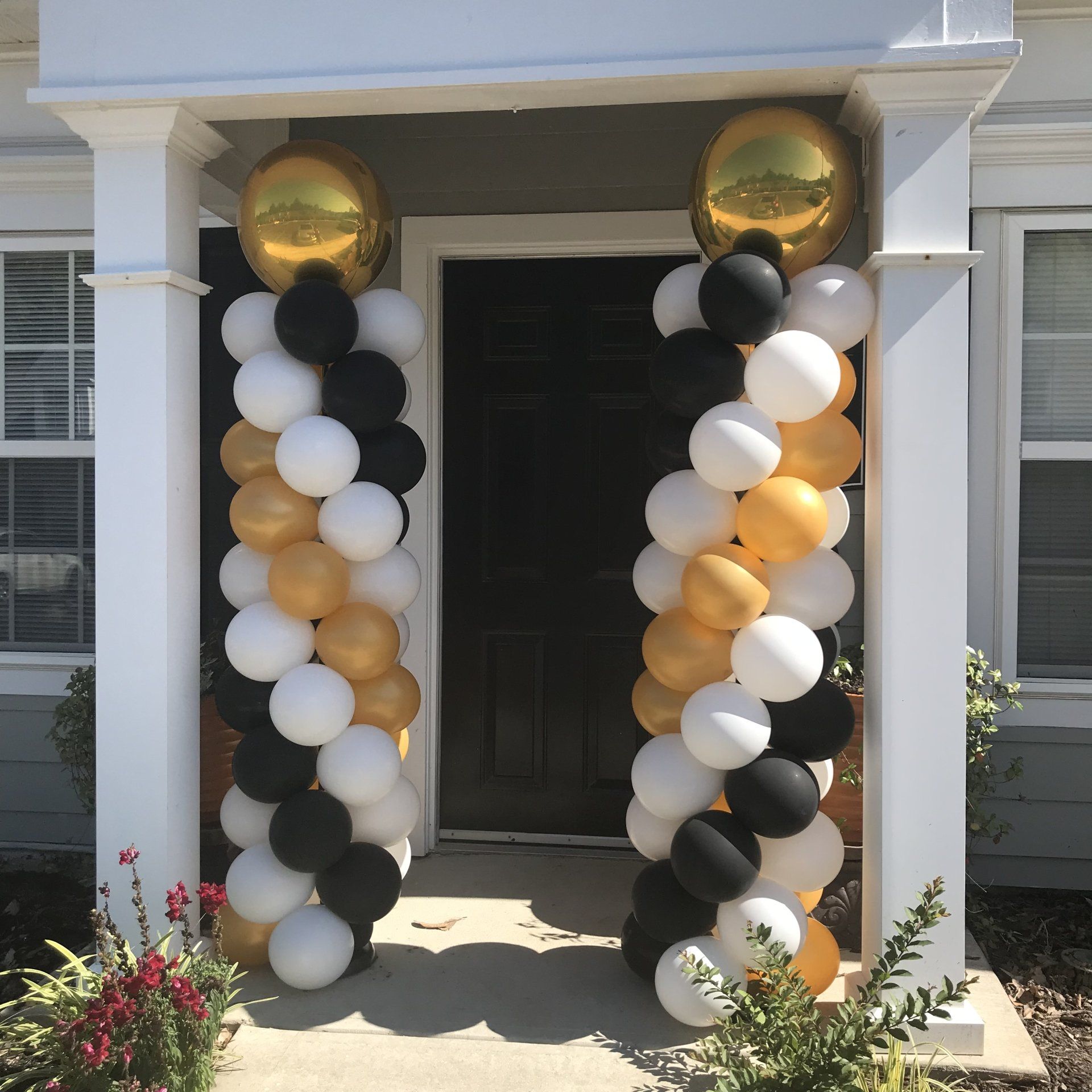 Welcoming columns at a entrance, created with multiple colors of balloons in a spiral design.