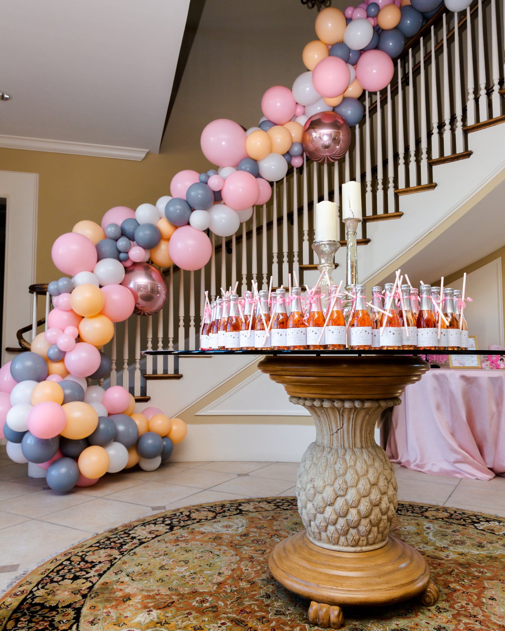 Pastel balloon garland cascading along staircase railing for baby shower home celebration decor