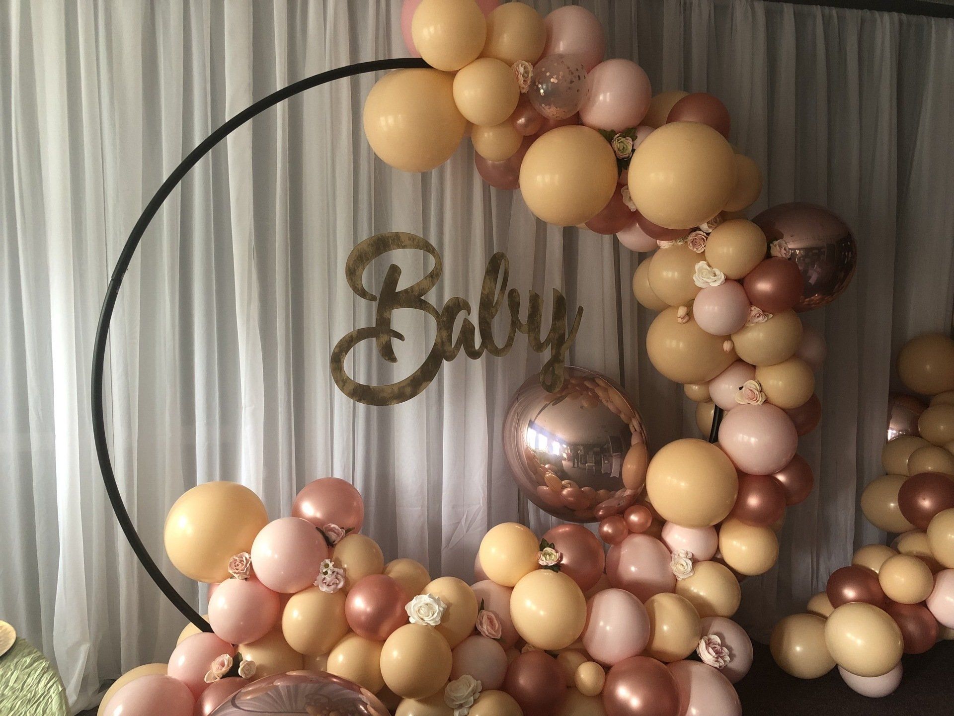 Boho nude and rose gold balloon ring backdrop with gold Baby sign for shower photo area