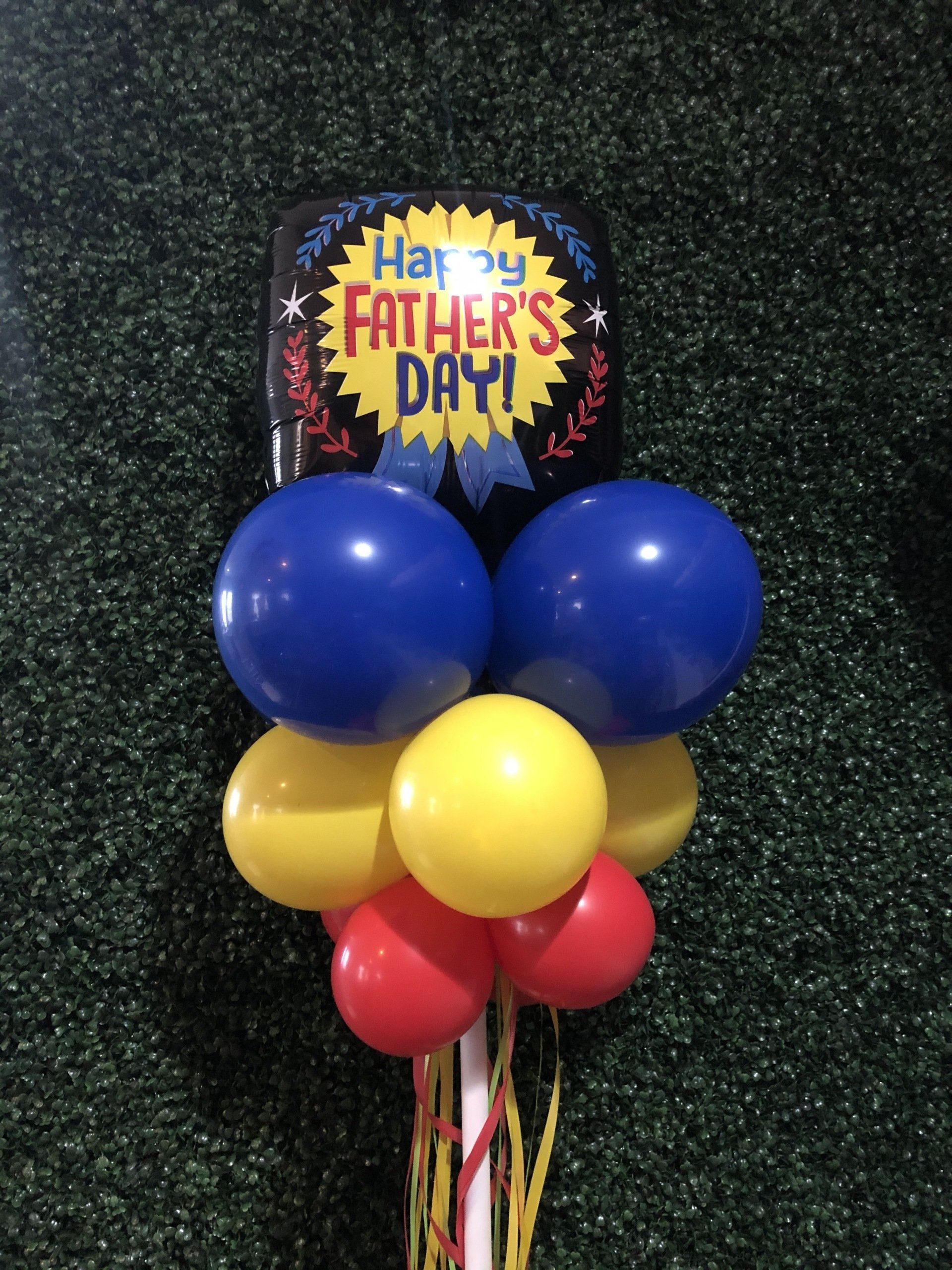 Happy Father’s Day foil balloon with blue latex balloons arranged for outdoor yard display
