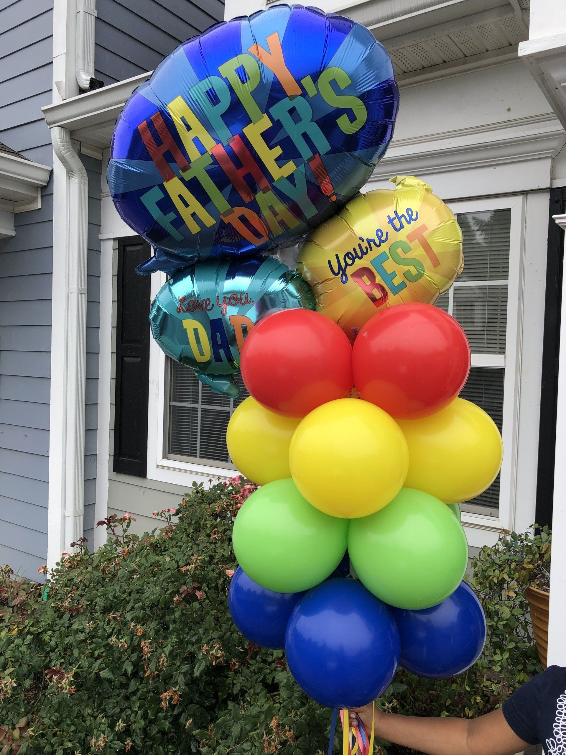 Happy Father’s Day balloon bouquet with colorful foil and latex balloons arranged on front porch