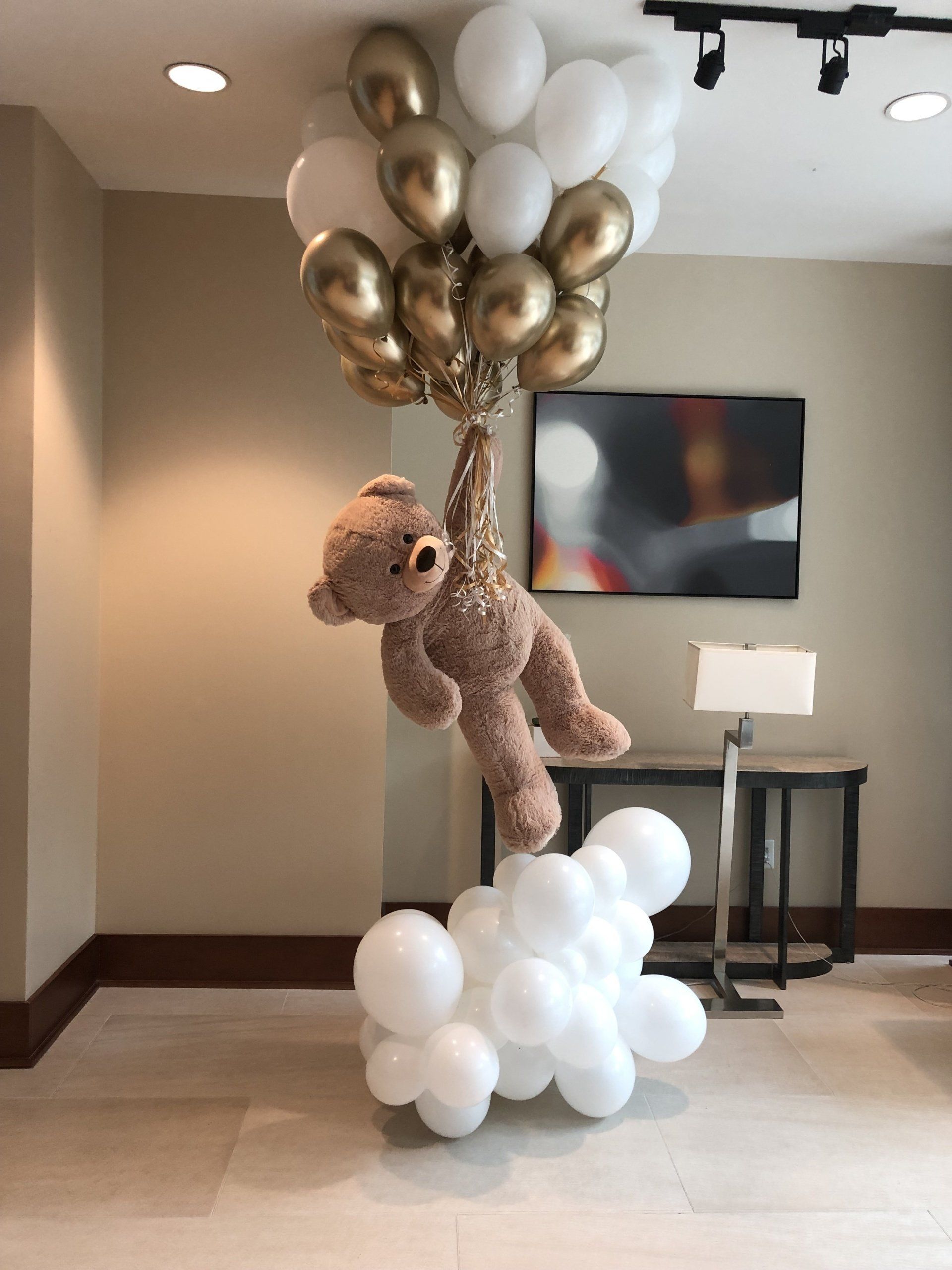 White and gold balloon bouquet cluster tied together for elegant indoor party or baby shower decor