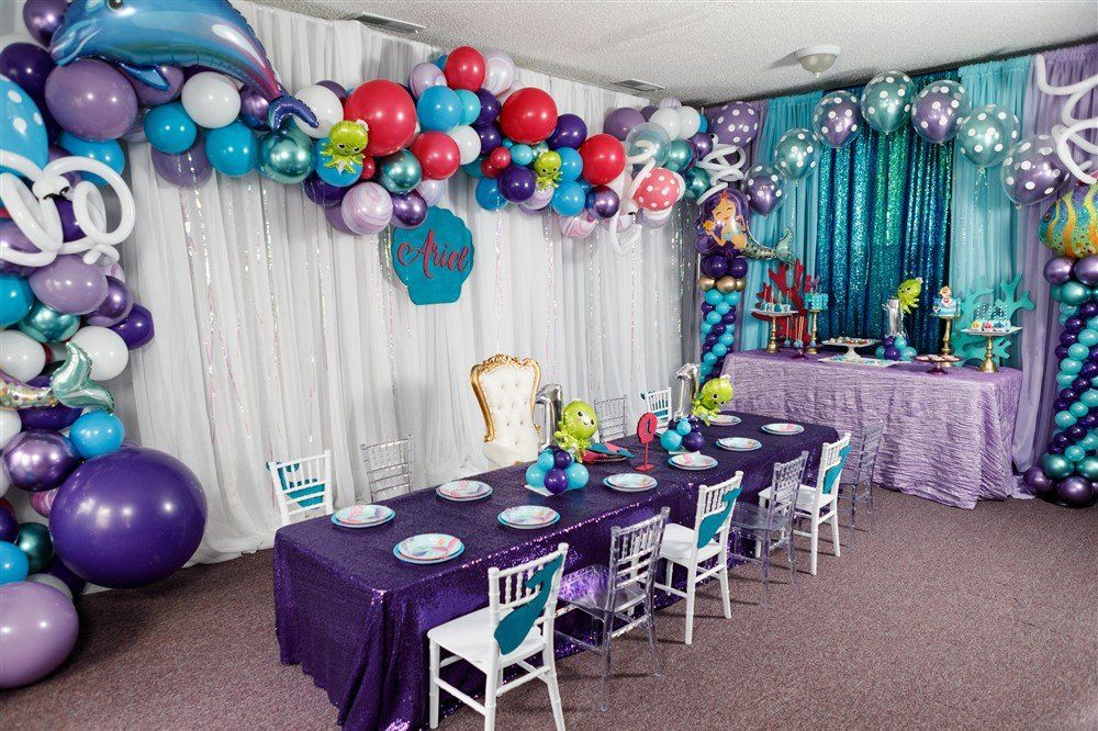 Under the sea themed kids party with purple and teal balloon garlands and mermaid décor