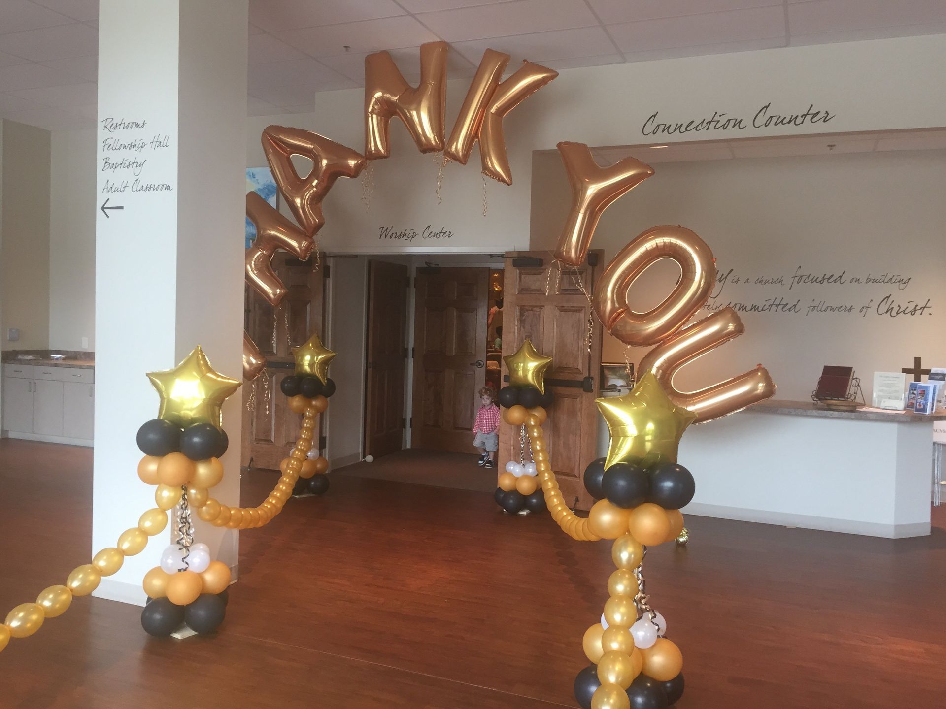 A welcome way consisting of balloon stanchions and a 