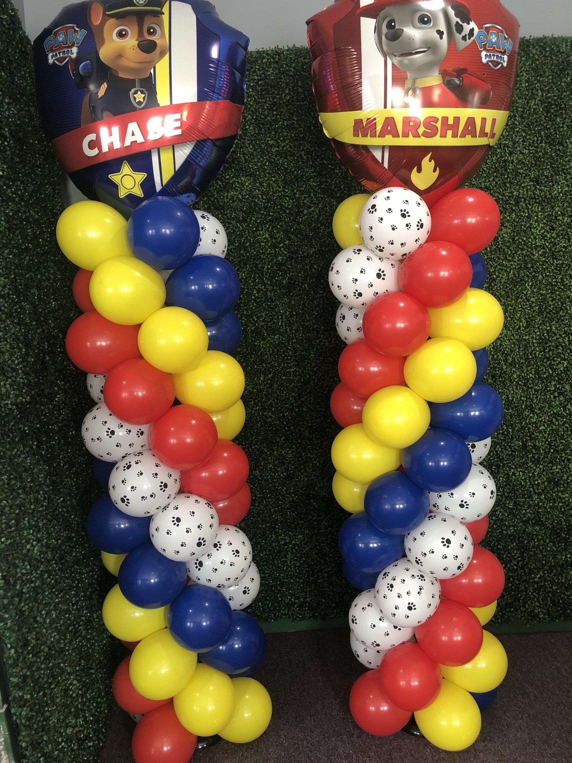 Paw Patrol themed balloon columns with character toppers and colorful balloon bases for a kids party