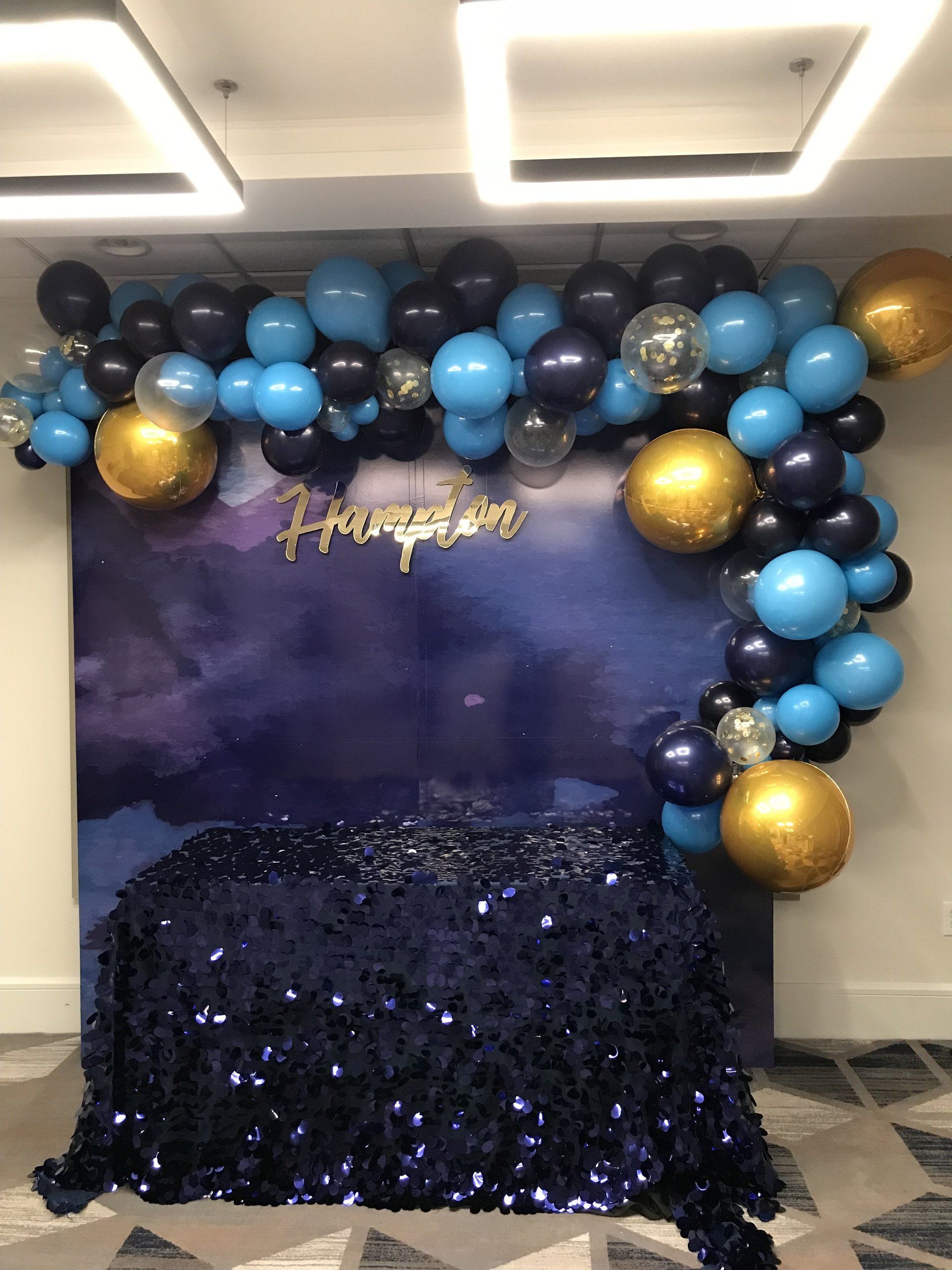 Blue black and gold balloon garland backdrop with custom name sign for birthday or celebration