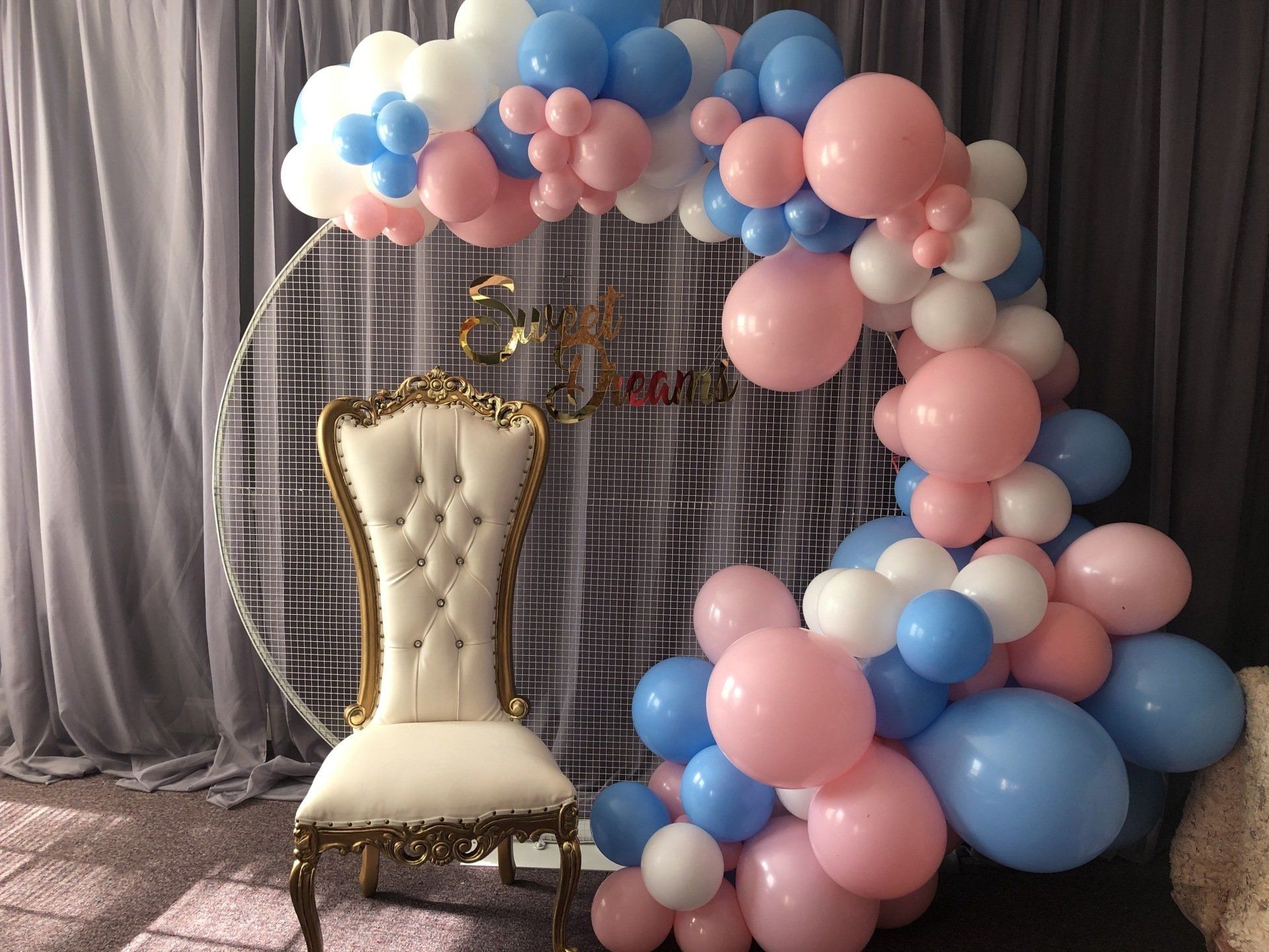Pastel pink blue and white balloon ring backdrop with white throne chair for baby shower or kids party