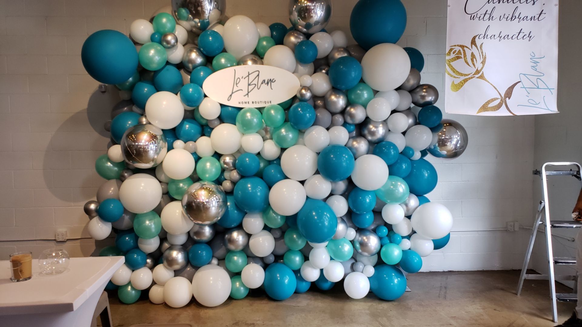 Teal, white, and silver organic balloon wall backdrop for baby shower or birthday event photo area