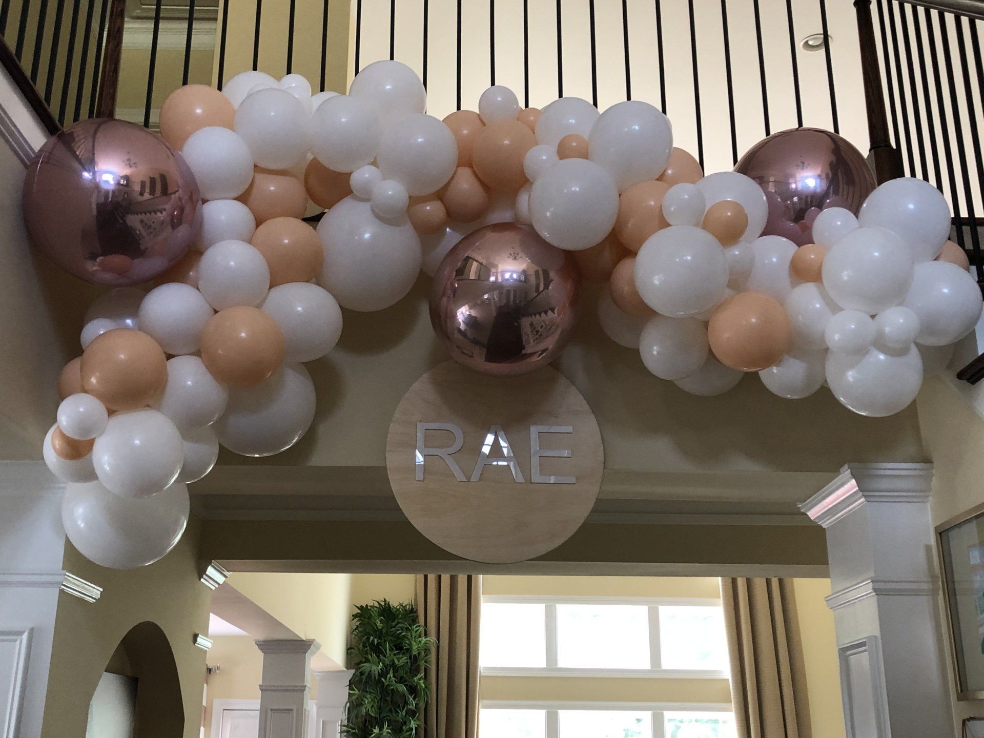 Neutral white blush and rose gold balloon garland with custom RAE name sign for baby shower