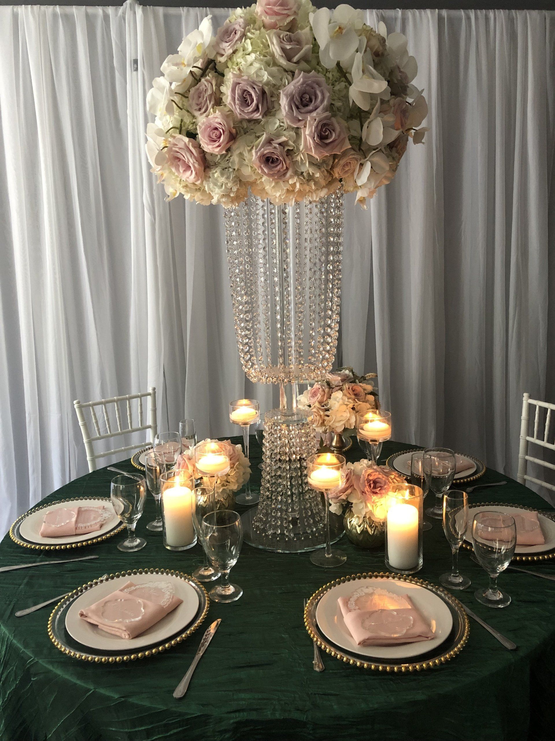 Round rose and hydrangea centerpiece on a crystal beaded stand with white draped backdrop
