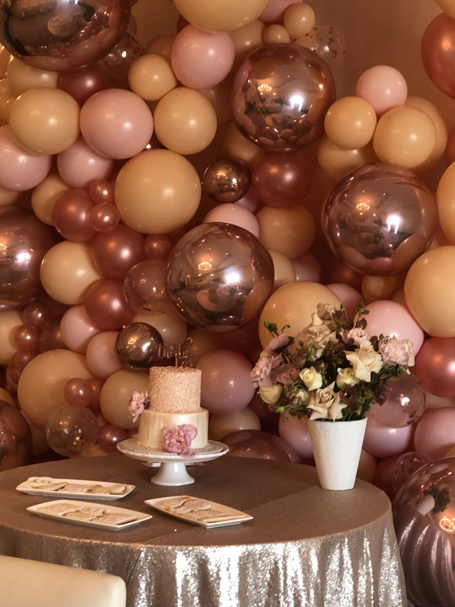 Close-up of blush nude and rose gold chrome balloon cluster for luxury baby shower decor
