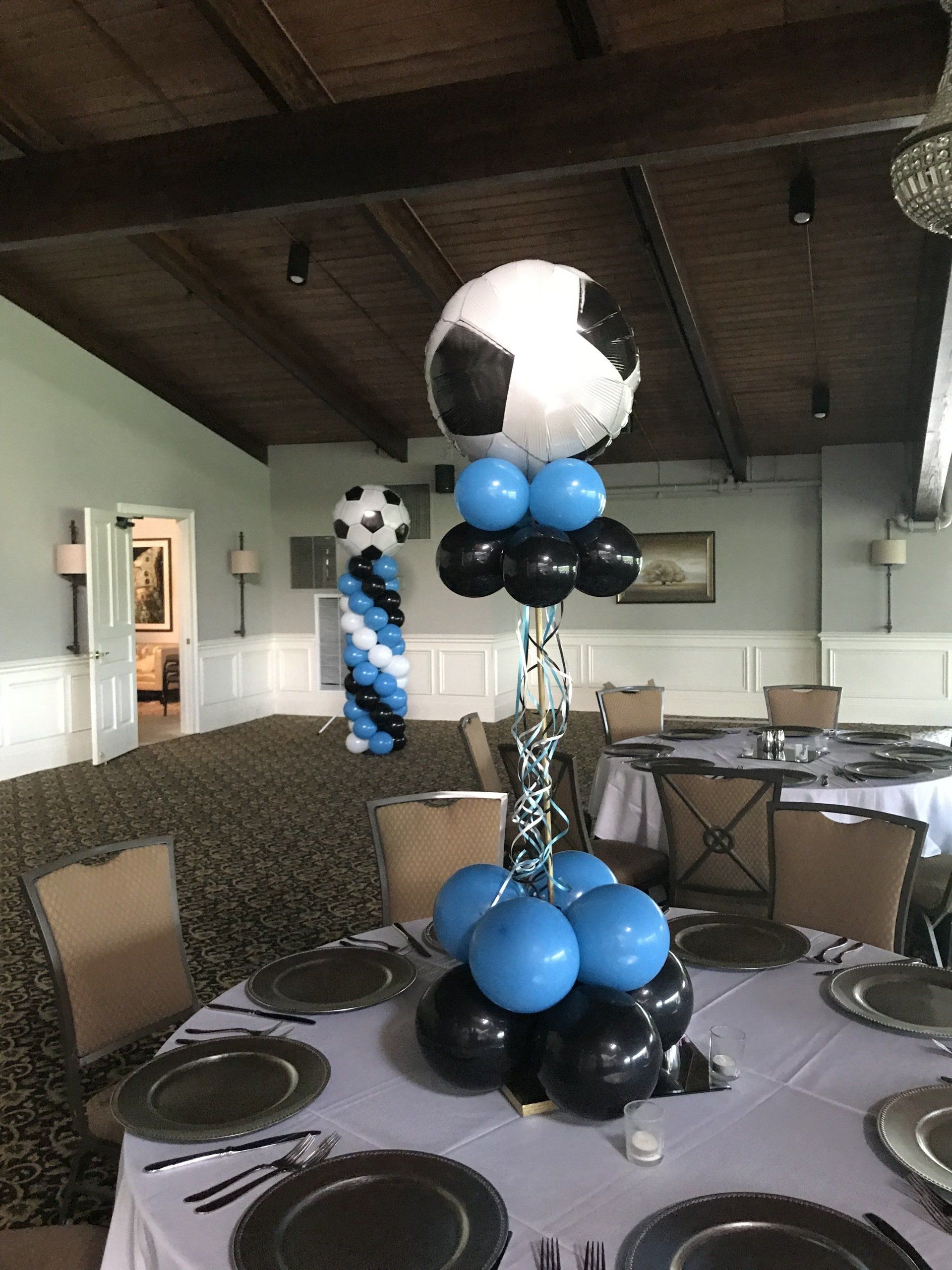 Close-up of a soccer ball balloon column with blue and black balloon base for a sports party