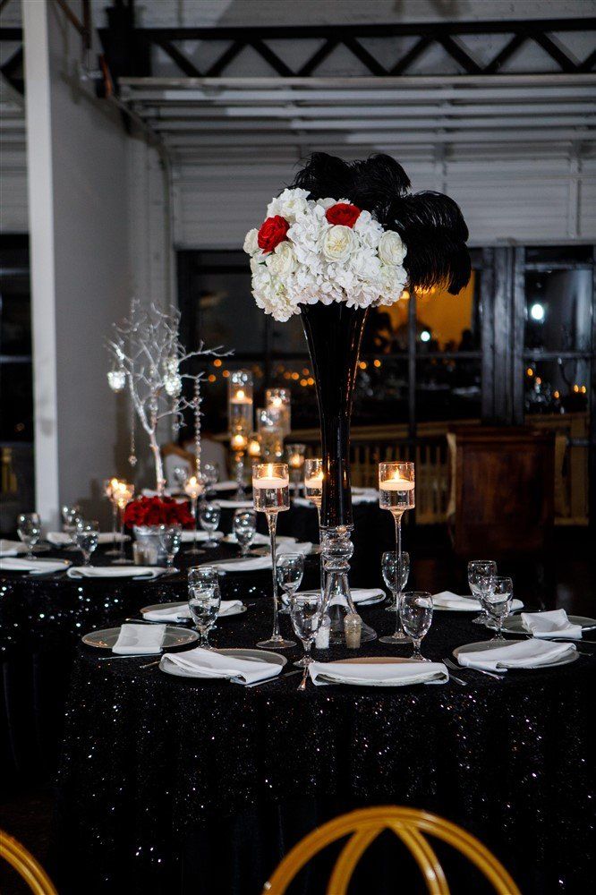 Black and white floral centerpiece with feather accents for glam themed event
