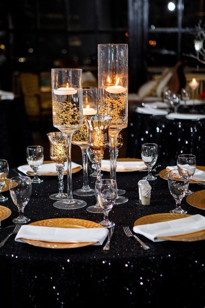 Glass cylinder vases with floating candles and gold accents for elegant table décor