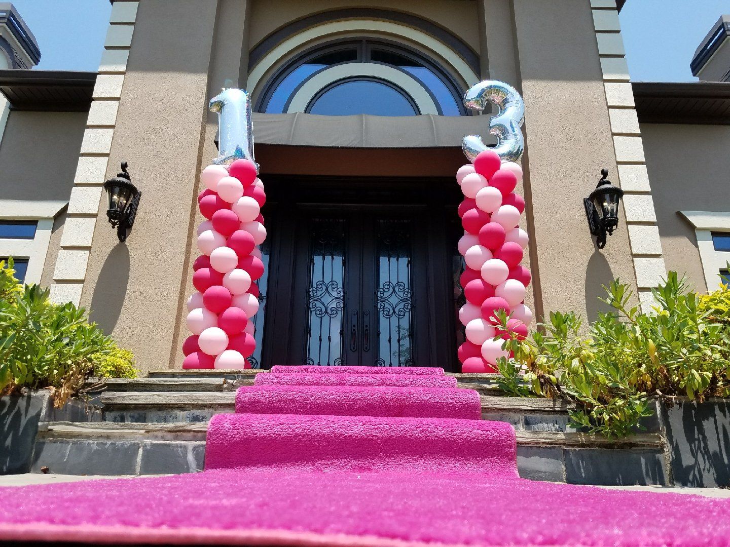 Shades of pink balloons create a spiral design for two columns with the number 1 on top of one and 3 on the other.