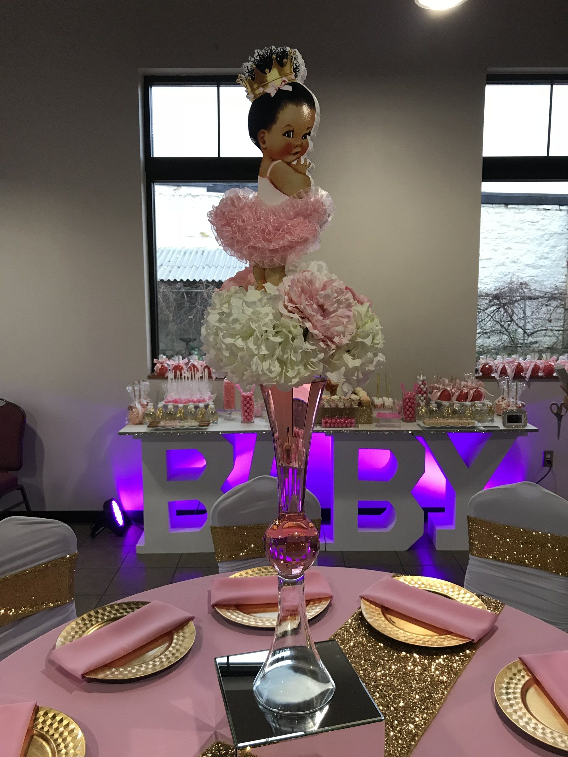 tall floral centerpiece sitting a mirrored cube base.