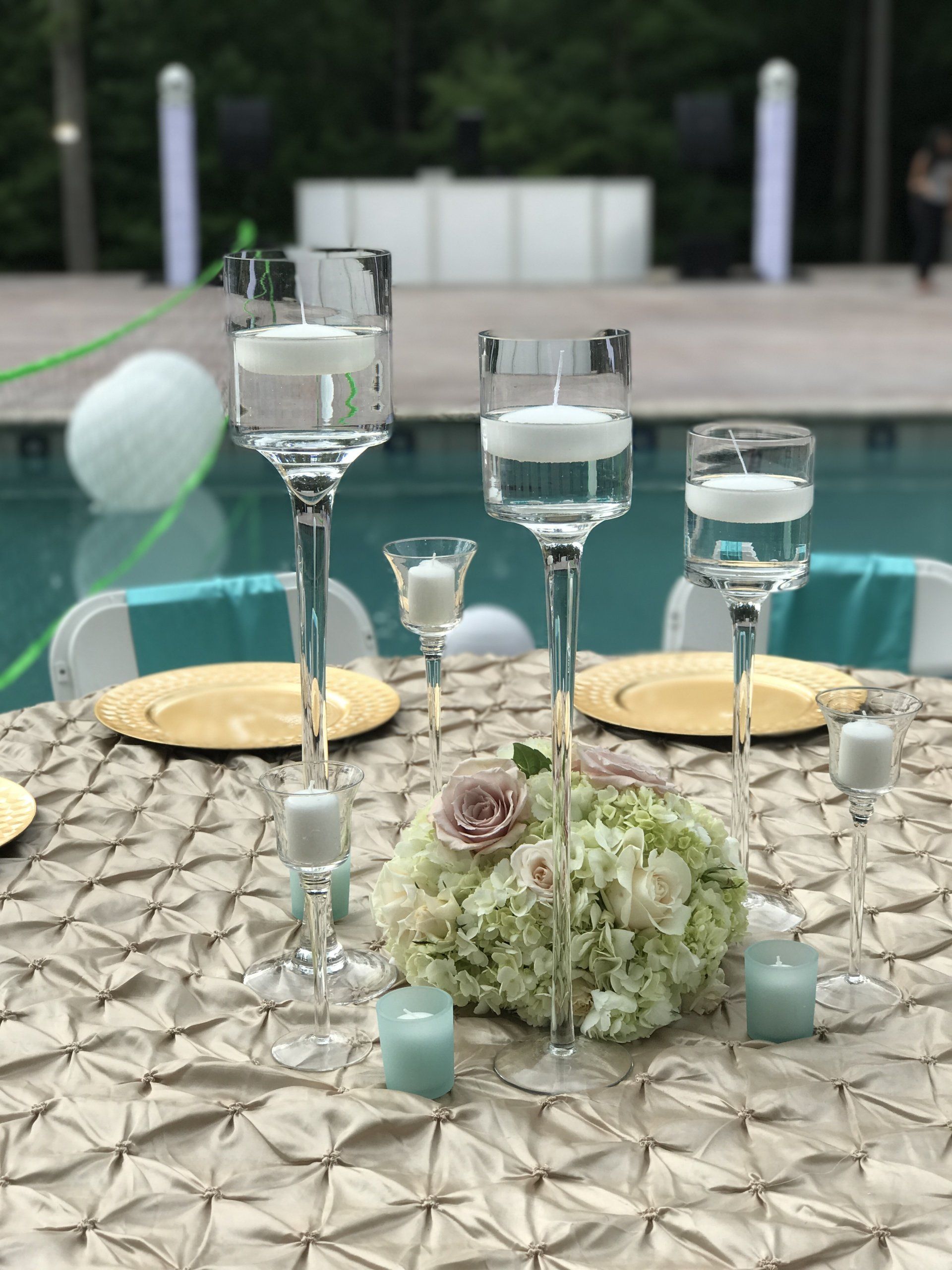 Outdoor event design with varying height tall floating candle holders