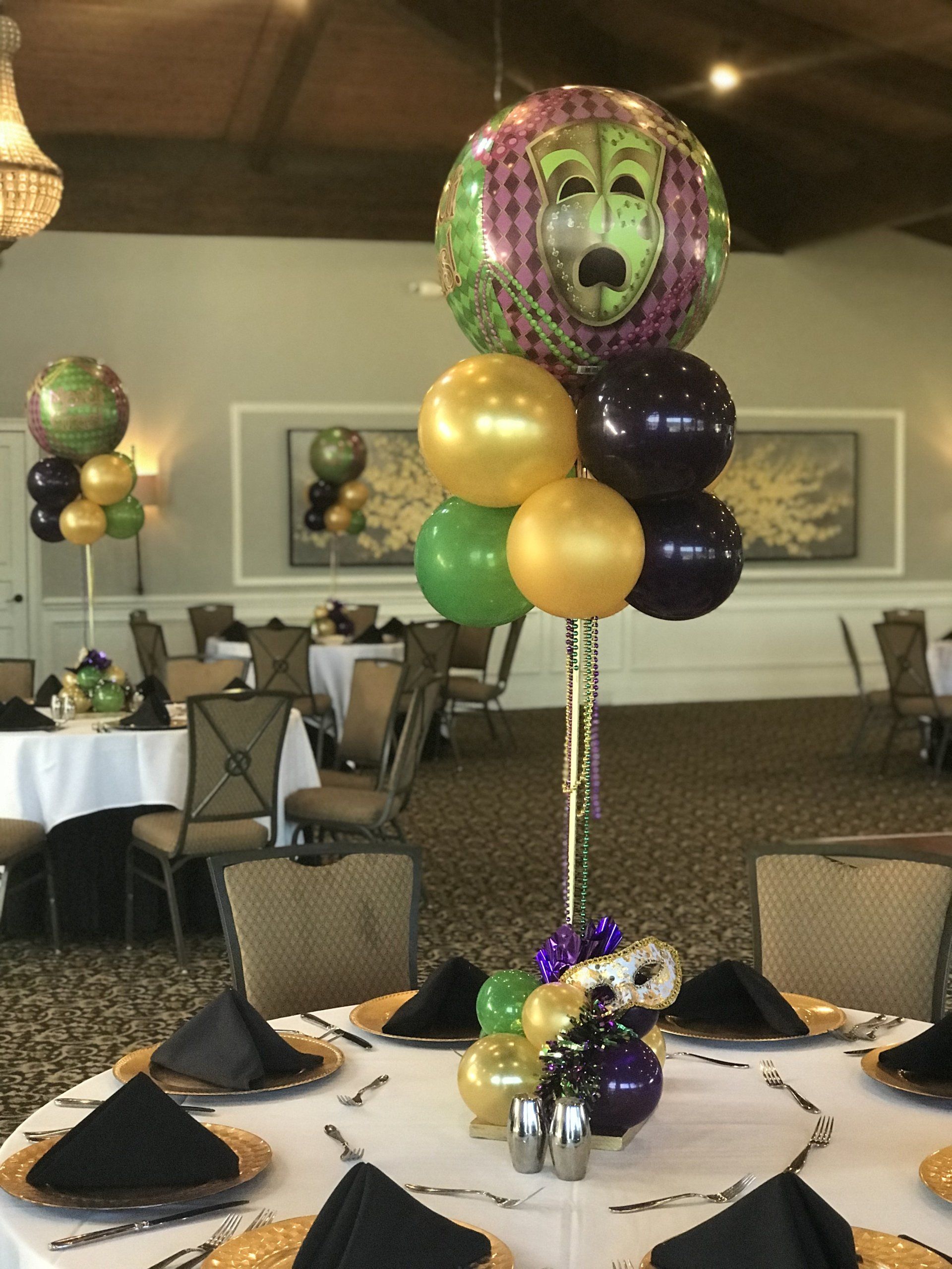 Mardi Gras themed balloon centerpieces adorned with beads and a mask.
