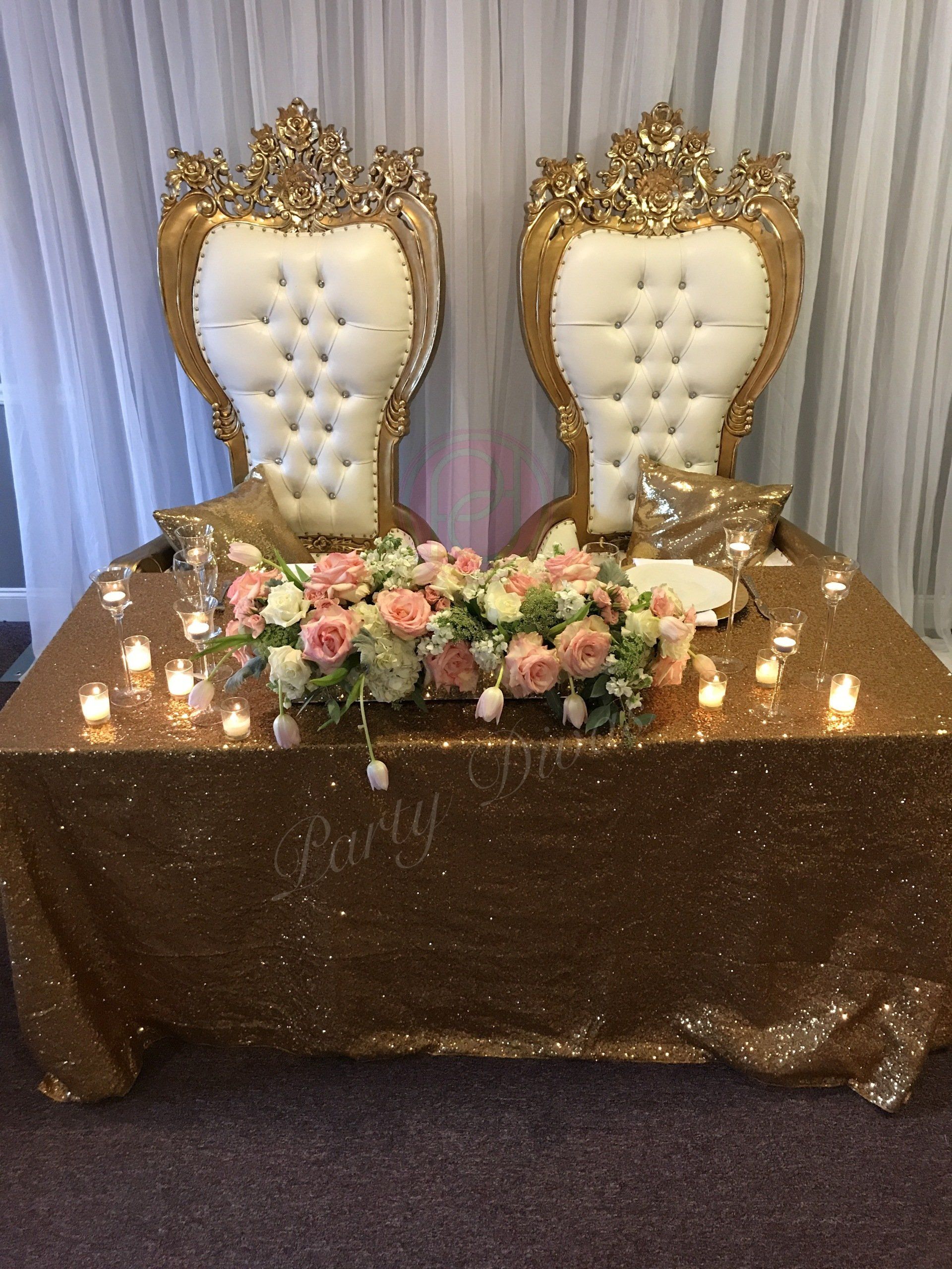 Gold trimmed thrones and draping are in the background.