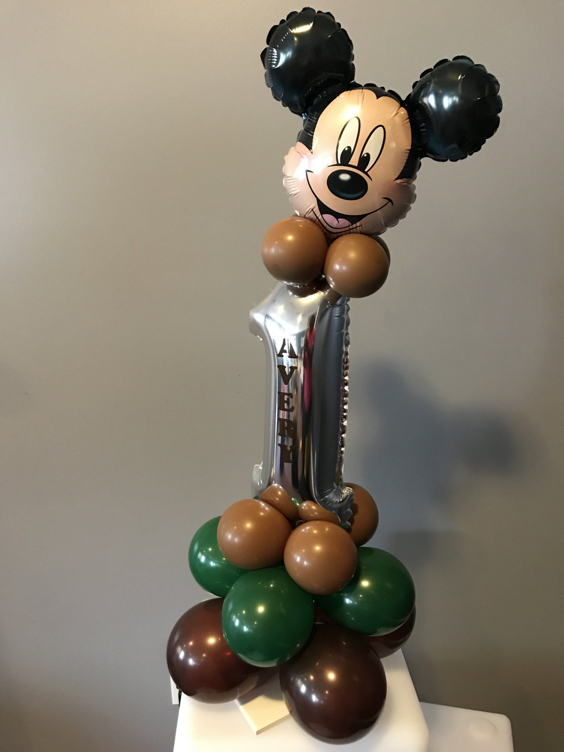 Micky Mouse is atop a balloon centerpiece.