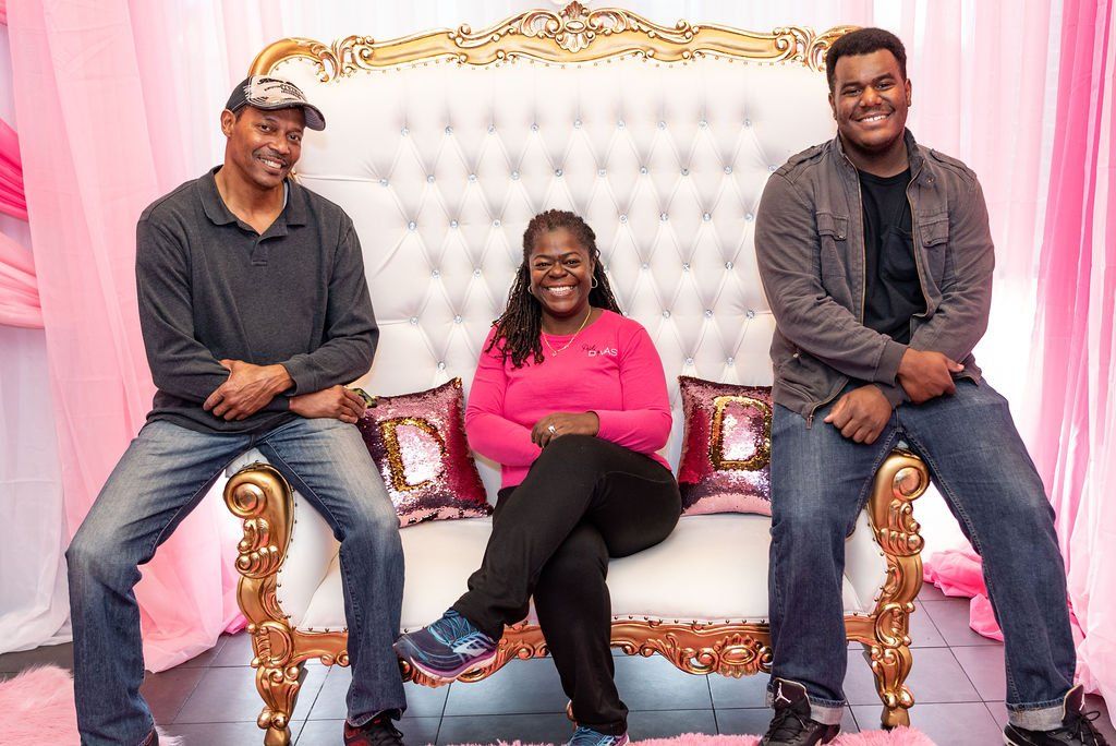 Party Divas team members seated together on a decorative sofa in the event studio