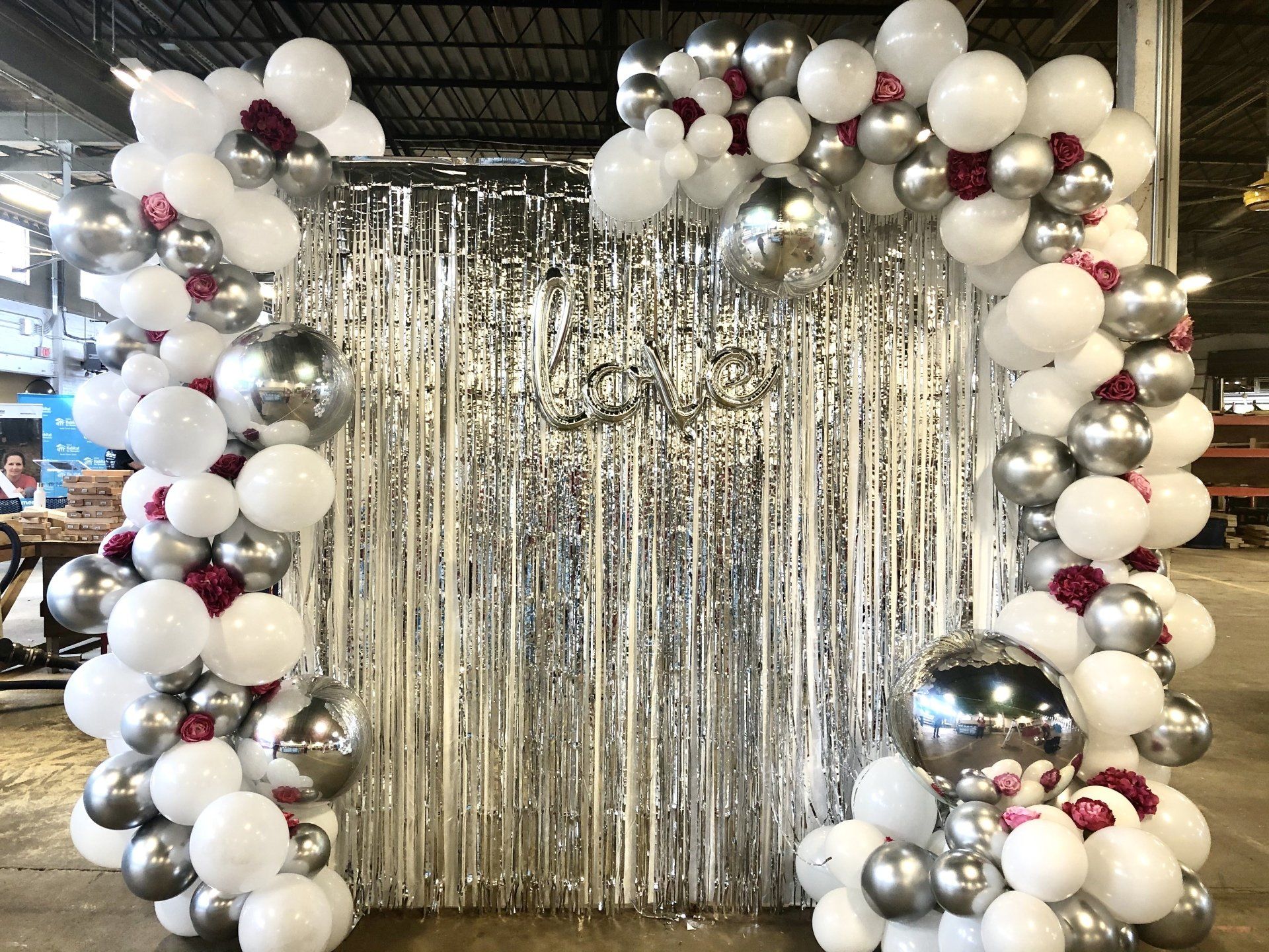 White silver and chrome balloon backdrop with metallic fringe curtain for celebration photo booth