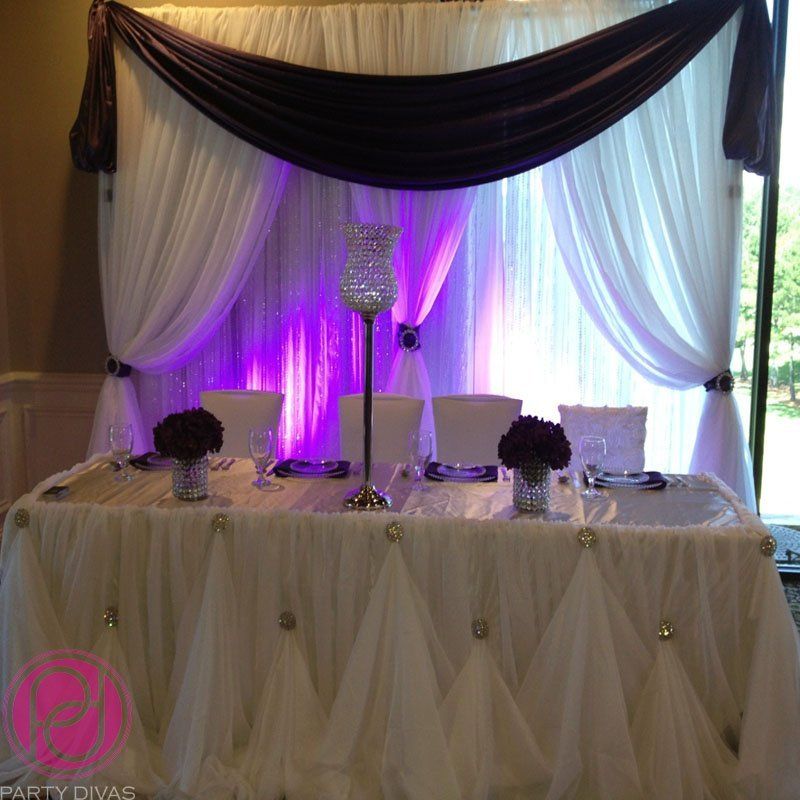 A beautiful head table with draping on the backdrop and on the front of the table.